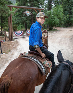Trail guide Marco keeps tabs on his riders as they pass the gate into the Ranch at Emerald Valley, Pike National Forest, Colorado Springs, CO / EVR_IMG_2365A - ©Steve Haggerty/ColorWorld
